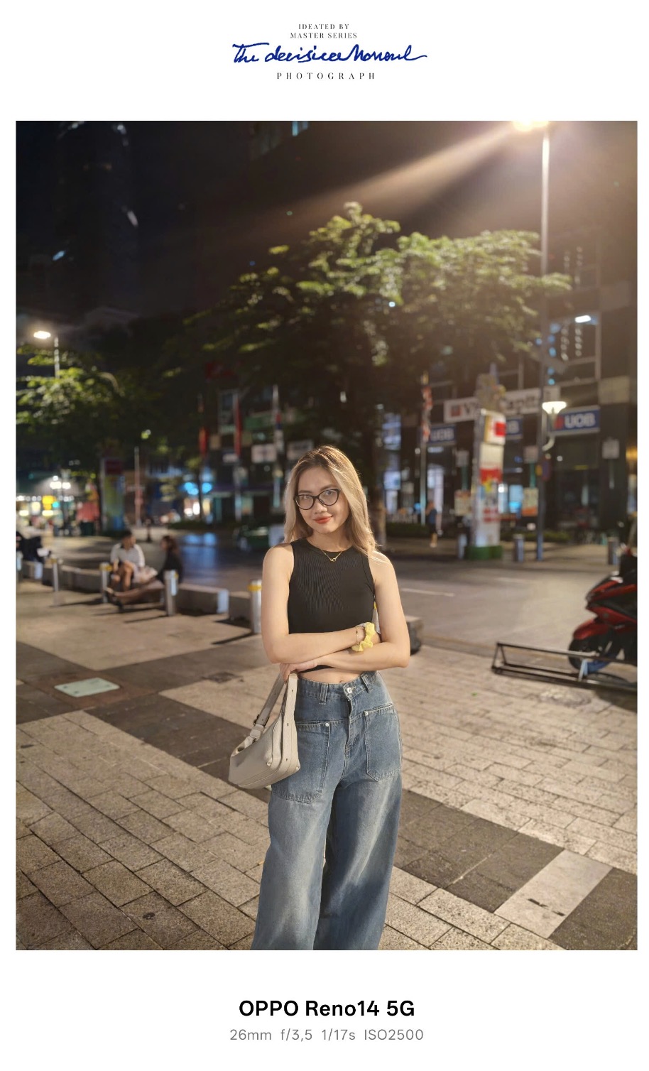 Trong điều kiện ngoài trời vào ban đêm, như tại một khu phố với các tòa nhà và đèn neon phức tạp, Reno14 5G thể hiện khả năng vượt trội. Một bức ảnh chân dung chụp tại 2x với flash “Always On” cho thấy chủ thể được chiếu sáng rõ ràng, với màu da tự nhiên và không bị cháy sáng. Nền phía sau, bao gồm các tòa nhà và ánh đèn, được xử lý tốt, không bị lóa hay mất chi tiết. Hệ thống AI giúp cân bằng ánh sáng giữa chủ thể và nền, mang lại bức ảnh hài hòa, phù hợp để chia sẻ ngay trên mạng xã hội.